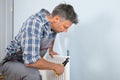 Plumber fixing radiator with wrench Royalty Free Stock Photo