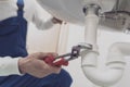 Plumber fixing a sink at home Royalty Free Stock Photo