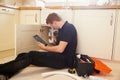 Plumber fixing sink in kitchen consulting tablet computer Royalty Free Stock Photo