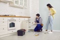 Plumber fixing some problems with the sink drain in the kitchen of a young woman's house Royalty Free Stock Photo