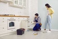 Plumber fixing some problems with the sink drain in the kitchen of a young woman's house