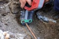 Plumber fixing an underground hot water pipe leaking with a tool Royalty Free Stock Photo