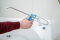 Plumber hand applying silicone sealant in the bathroom.