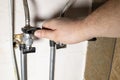 Hand installs water stop tap by adjustable wrench