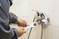 Plumber hands fixing water tap with spanner