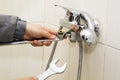 Plumber hands fixing water tap with spanner