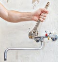 Plumber hands fixing water tap valve faucet using adjustable sp