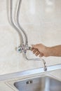 Plumber hands unscrew kitchen faucet vertical view