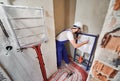 Plumber installing wall-hung toilet system in bathroom.