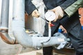 Plumber installing manometer on pipe Royalty Free Stock Photo