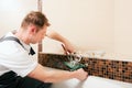 Plumber installing a mixer tap in a bathroom Royalty Free Stock Photo