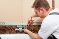 Plumber installing a mixer tap in a bathroom Royalty Free Stock Photo