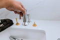 Plumber installing new mixer tap hands worker close up repair in bathroom at home Royalty Free Stock Photo