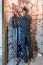 Plumber installing water pipes in a new bathroom, seen from behind Royalty Free Stock Photo