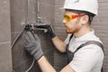 Plumber installing water taps shower stall, work in bathroom Royalty Free Stock Photo