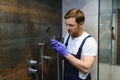 Plumber installing water taps shower stall, work in bathroom. Royalty Free Stock Photo