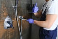 Plumber installing water taps shower stall, work in bathroom. Royalty Free Stock Photo