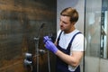 Plumber installing water taps shower stall, work in bathroom. Royalty Free Stock Photo