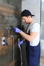 Plumber installing water taps shower stall, work in bathroom. Royalty Free Stock Photo