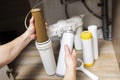 Plumber installs or change water filter. Replacement aqua filter. Repairman installing water filter cartridges in a kitchen. Clean