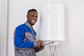 Plumber Looking At Electric Boiler Royalty Free Stock Photo