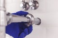 Plumber maintains chrome universal escutcheon on siphon pipe under the washbasin. Plumber at work in bathroom, plumbing