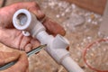 Plumber makes marks on the plastic fittings using a pencil.
