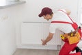 Plumber man is blocking repairs radiators of heating battery in apartment tap