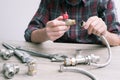 Plumber measures the size of fitting before connecting water pipe. Plumber connects fittings while repairing equipment. Close-up Royalty Free Stock Photo