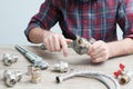 Plumber measures the size of fitting before connecting water pipe. Plumber connects fittings while repairing equipment. Close-up