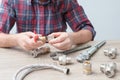 Plumber measures the size of fitting before connecting water pipe. Plumber connects fittings while repairing equipment. Close-up