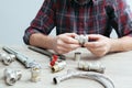 Plumber measures the size of fitting before connecting water pipe. Plumber connects fittings while repairing equipment. Close-up