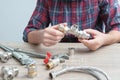 Plumber measures the size of fitting before connecting water pipe. Plumber connects fittings while repairing equipment. Close-up