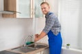 Plumber With Plunger In Kitchen