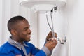 Plumber Repairing Electric Boiler Royalty Free Stock Photo