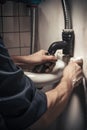 Plumber repairing a sink in a bathroom. Selective focus. Toned.