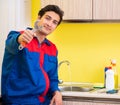 Plumber repairing tap at kitchen Royalty Free Stock Photo