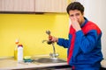 Plumber repairing tap at kitchen Royalty Free Stock Photo