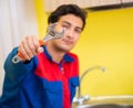 Plumber repairing tap at kitchen Royalty Free Stock Photo