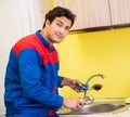 Plumber repairing tap at kitchen Royalty Free Stock Photo