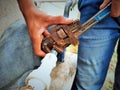 Plumber repairing water fitting with adjustable wrench Royalty Free Stock Photo