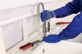 Plumber repairing water tap in kitchen, closeup Royalty Free Stock Photo