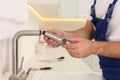 Plumber repairing water tap in kitchen, closeup Royalty Free Stock Photo