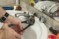 plumber repairs the faucet in the bathroom Royalty Free Stock Photo