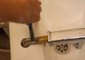 Plumber repairs a leaky faucet in bathroom Royalty Free Stock Photo