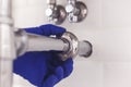 Plumber repairs and maintains chrome siphon under the washbasin. Plumber at work in bathroom, plumbing assemble and