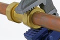 Plumber`s adjustable wrench tightening up copper pipework Royalty Free Stock Photo