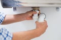 Plumber's hands and washbasin drain at bathroom Royalty Free Stock Photo