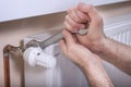 Plumber`s male hands hold a flat wrench by which they unscrew the temperature control valve. Royalty Free Stock Photo