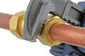 Plumber`s wrench tightening up copper pipework Royalty Free Stock Photo